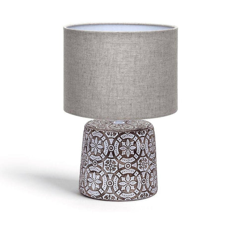 Dekorative Tischlampe aus Keramik mit Ornamenten und rundem Stoffschirm.