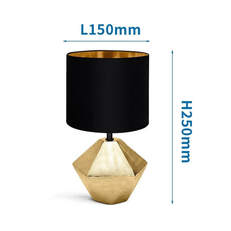 Edle goldfarbene Tischlampe aus Keramik mit 6-eckigem Fuss und schwarzem Stoffschirm.