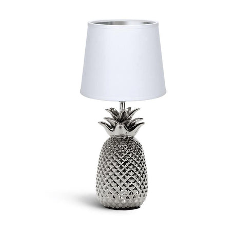 Moderne silberfarbene Tischlampe in Ananas-Optik mit weißem Stoffschirm.