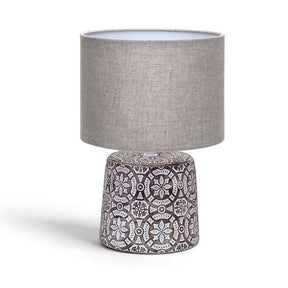 Dekorative Tischlampe aus Keramik mit Ornamenten und rundem Stoffschirm.